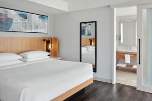1 Schlafzimmer mit einem weißen Bett und einem Badezimmer in der Unterkunft Delta Hotels by Marriott Toronto in Toronto