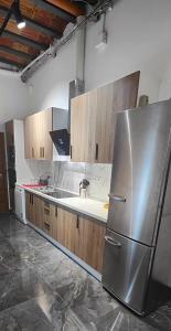 una cocina con nevera de acero inoxidable y armarios de madera en Beautiful Appartment in Martorell (Barcelona), en Martorell