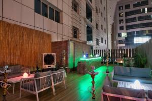 a rooftop patio with green lights in a building at Grandeur Hotel Al Barsha in Dubai