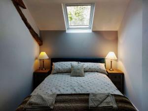 a bedroom with a bed with two lamps and a window at Cae Tudur Remote Rural Cottage near Barmouth in Barmouth