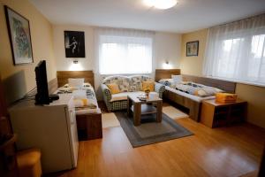 uma sala de estar com duas camas e uma televisão em Penzion Harmonia em Liptovský Mikuláš