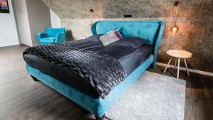 een bed met een blauw hoofdeinde in een kamer bij Ocean House Penthousewohnung Wolke 7 mit Whirlpool in Timmendorfer Strand