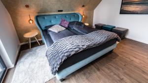 een slaapkamer met een groot bed met een blauw hoofdeinde bij Ocean House Penthousewohnung Wolke 7 mit Whirlpool in Timmendorfer Strand