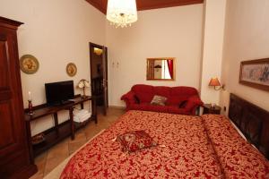 1 dormitorio con cama roja y sofá rojo en B&B LA POSADA, en SantʼAntìoco