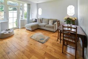 a living room with a couch and a table at BOURNECOAST: GROUND FLOOR - GARDEN - WIFI - FM6096 in Iford