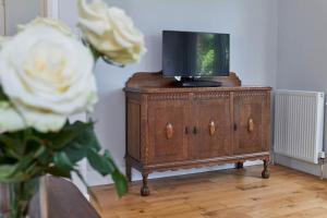 a tv sitting on top of a wooden dresser at BOURNECOAST: GROUND FLOOR - GARDEN - WIFI - FM6096 in Iford