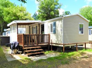 サン・ジャン・ド・モンにあるBungalow de 2 chambres avec piscine partagee terrasse amenagee et wifi a Saint Jean de Monts a 1 km de la plageの小さな家 ポーチとデッキ付