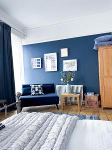 a bedroom with a blue wall and a blue couch at View at 142 in The Mumbles