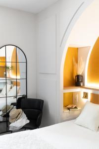 a bedroom with a black chair and a mirror at Best Western Hotel du Roy d'Aragon in Bonifacio