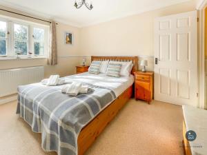 a bedroom with a large bed with two towels on it at Wildflower Cottage - Sutton Poyntz in Preston