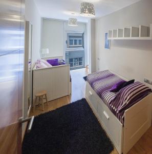 um pequeno quarto com uma cama e uma janela em Sakura Homes Torre de Hércules 7 plazas em La Coruña