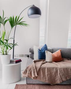 sala de estar con sofá con almohadas y planta en Divine Views from a Breathtaking LuxXe City Penthouse for a Gracious Life Style, en Londres