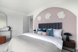 1 dormitorio blanco con 1 cama blanca grande con nubes en la pared en Divine Views from a Breathtaking LuxXe City Penthouse for a Gracious Life Style, en Londres