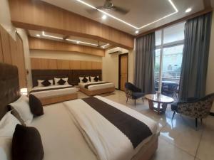 Un dormitorio con dos camas y una gran ventana. en Hotel Jai Palace, en Ajmer