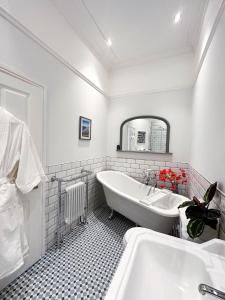a white bathroom with a tub and a sink at View at 142 in The Mumbles