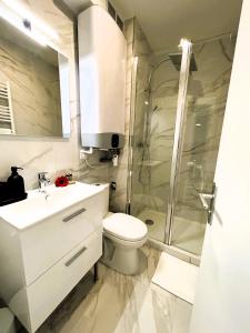 a bathroom with a toilet and a glass shower at La Maison Hugo in Montreuil