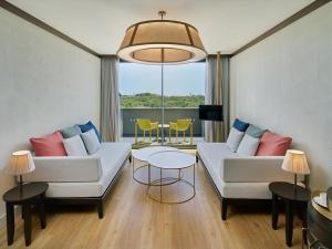 a living room with two white couches and a table at Voyage Belek Golf & Spa Hotel in Belek