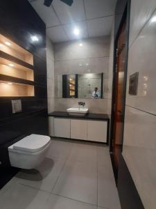 Un baño con inodoro, lavabo y espejo. en Hotel Jai Palace, en Ajmer