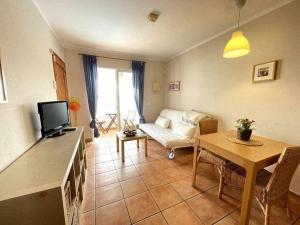 a living room with a couch and a table at Galdana - Apartamento con piscina in Cala en Blanes