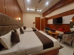 a hotel room with two beds and a desk at Hotel Jai Palace in Ajmer