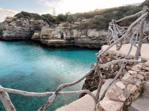 a view of a body of water next to some rocks at Galdana - Apartamento con piscina in Cala en Blanes