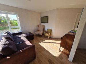ein Wohnzimmer mit einem Sofa und einem TV in der Unterkunft The Poets Cottage in Ballymena