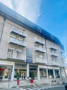 un edificio con balcones blancos en su lateral en Résidence Le Grand Tétras- SPA THERMAL INCLUS, en Ax-les-Thermes