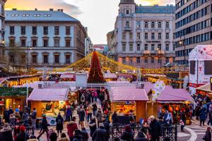 uma multidão de pessoas andando em torno de um mercado de Natal em Dunapest Apartman em Budapeste
