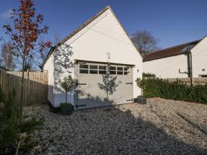 a white building with a garage with a fence at The Annex in Pershore