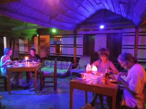 un gruppo di persone sedute ai tavoli di un ristorante di Viraj's Garden a Tangalle