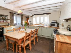 FeethamにあるPursglove Cottageの木製テーブルと椅子付きの広いキッチン