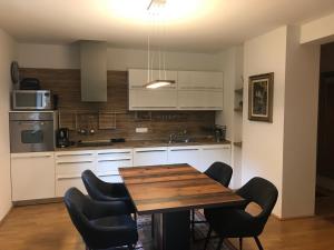 a kitchen with a wooden table and black chairs at Enzian 14 - Schmuckstück von Bad Kleinkirchheim in Bad Kleinkirchheim