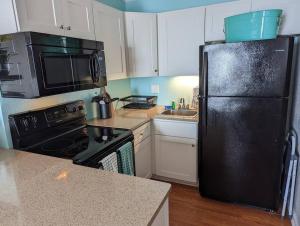 a kitchen with a black refrigerator and a sink at Seaside Joy - This is your happy place! in North Topsail Beach +26 photos