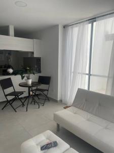 uma sala de estar com um sofá branco e uma mesa em Ubicación Inigualable Pinares Circunvalar em Pereira