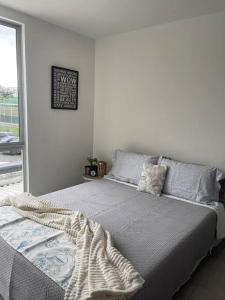 um quarto com uma cama com um cobertor em Ubicación Inigualable Pinares Circunvalar em Pereira
