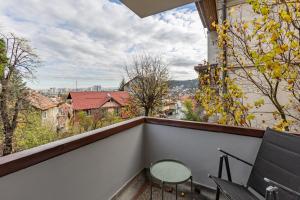 a balcony with a table and chairs and a view at Cranta Hillside Apartment in Braşov