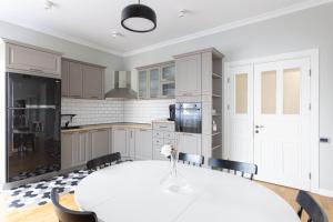 a white kitchen with a white table and chairs at Cranta Hillside Apartment in Braşov