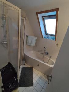 a bathroom with a bath tub and a shower at Ferienwohnung Am Ems-Seitenkanal 65353 in Moormerland