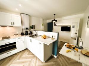 a kitchen with white cabinets and a counter top at La Maison Hugo in Montreuil