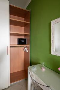 a green kitchen with a counter and a microwave at Renza House Chiaia in Naples