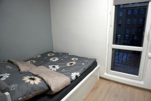 Dormitorio pequeño con cama junto a una ventana en Apartament Chorzów Centrum Wróblewskiego, en Chorzów
