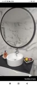 un lavabo con espejo y un bol de fruta en Beautiful 1-Bed House in Korce, en Korçë
