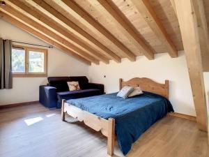 een slaapkamer met een bed en een bank bij Le Vivier in Saint-Gervais-les-Bains