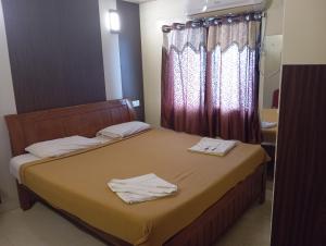 a bedroom with a bed with two towels on it at Hotel Western Park in Port Blair