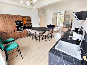 cocina y sala de estar con mesa y sillas en Inédit : appartements grandes capacités sur les quais de Blois - 23 pers, en Blois