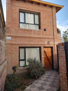 a brick house with two windows and a door at Casa de Playa in Puerto Madryn