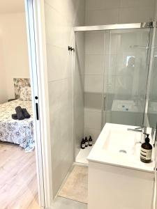 a white bathroom with a shower and a sink at Piso recien reformado, junto a Gran Via in Madrid