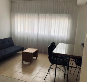 a living room with a table and chairs and a couch at Complejo Sol - Departamento 4 in Concordia