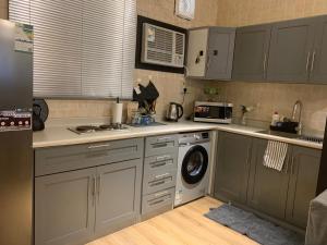 a kitchen with a washing machine and a microwave at Taibah Apartment in Medina