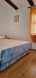 a bedroom with a bed with a blue bed frame at Apartments Mory in Kornić
